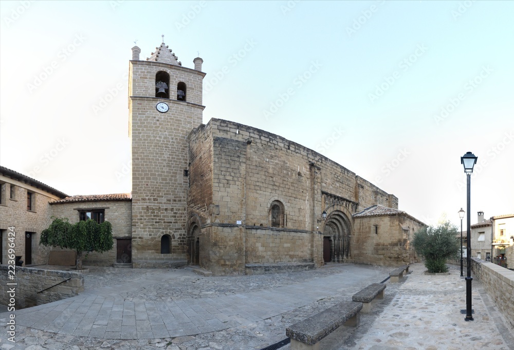 The Romanesque stone made Nicholas of Bari Church (Iglesia de san Nicolas de Bari), with the baroque bell tower and the front square in the small rural Aragonese town of Frago, Spain