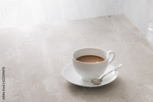 White china cup of tea with milk on a plain background