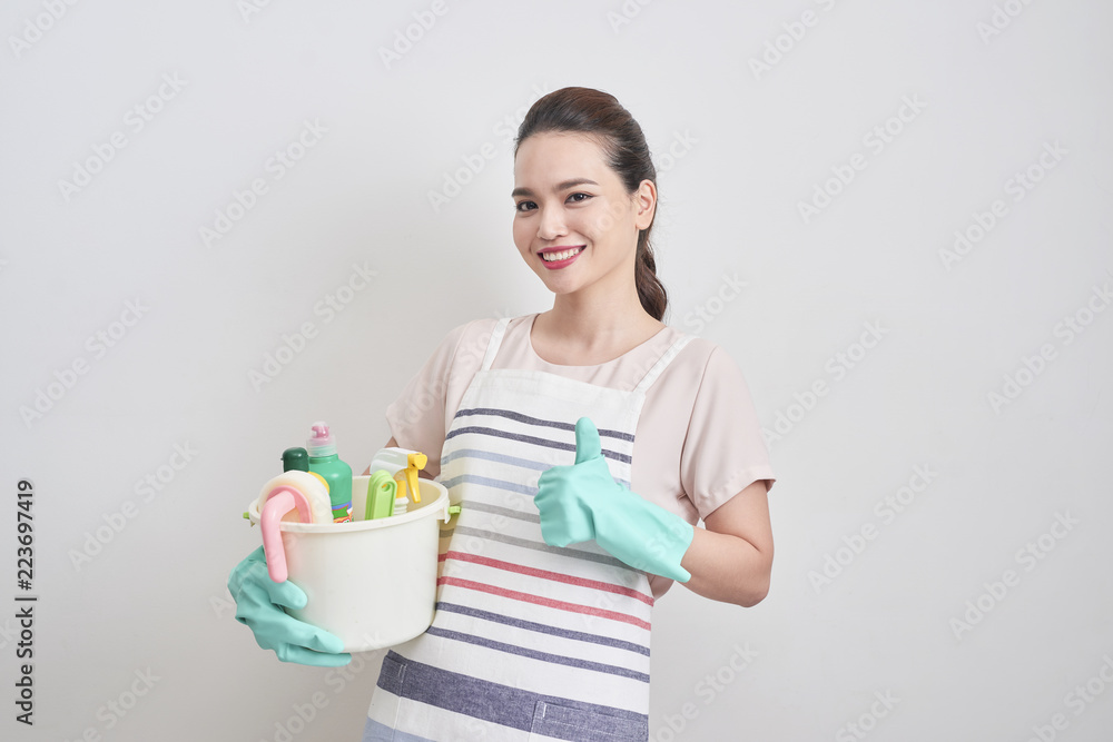 Happy smiling housewife holding cleaning tools and showing thumbs up isolated on white background. Cleaning service, housekeeping concept Happy smiling housewife holding cleaning tools and showing thumbs up isolated on white background. Cleaning service, housekeeping concept