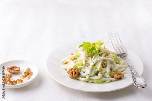 Traditional Waldorf salad with celery, apple, walnut and yoghurt dressing on white background, selective focus, horizontal