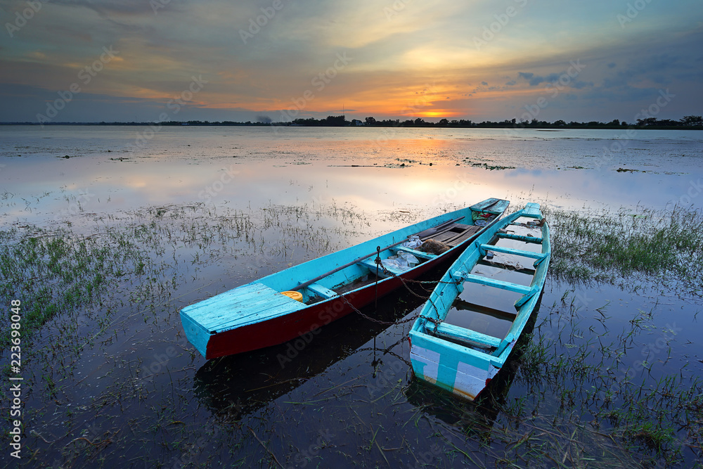 Small fishing boat with lake water at sunset, Thailand Small fishing boat with lake water at sunset, Thailand