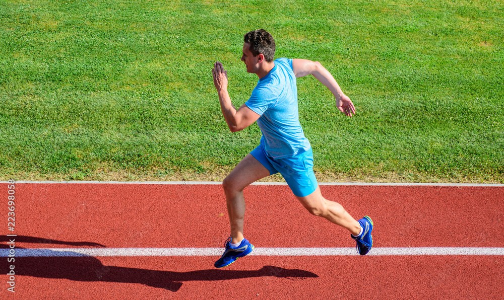 Obraz premium Sprinter training at stadium track. Progress and achievement. Training before take part in marathon. Man captured in motion. Sprinter athlete run training. Athlete run track grass background