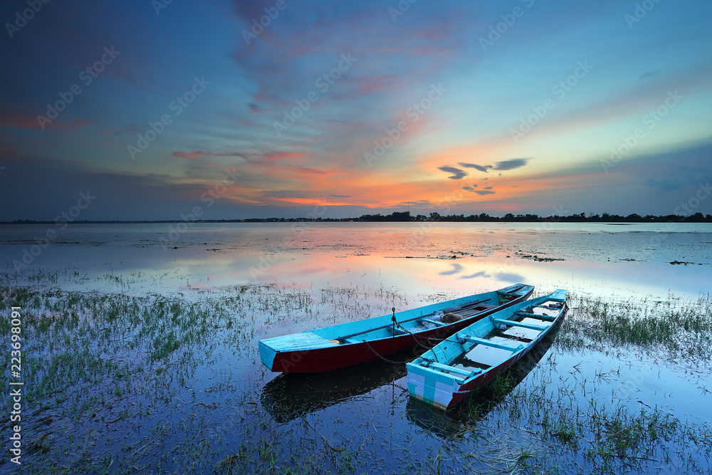 Small fishing boat with lake water at sunset, Thailand
