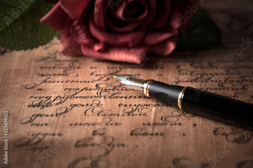 fountain pen on letter with text and red rose