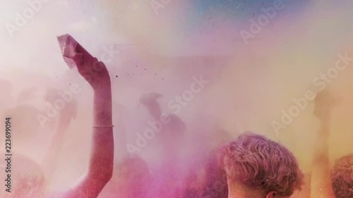Celebration of Holi colors festival. Young people dancing and enjoying music at open air festival.