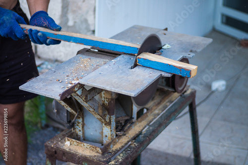 A man is sawing wood on a sawmill, prepared for the winter, makes logs © Alina_Huzova