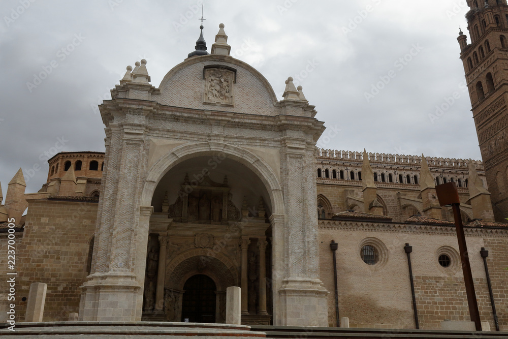 The Nuestra Señora de la Huerta gothic and mudejar cathedral facade, seen from the entrance staircase in perspective, in a cloudy, autumn day in Tarazona, Aragon, Spain