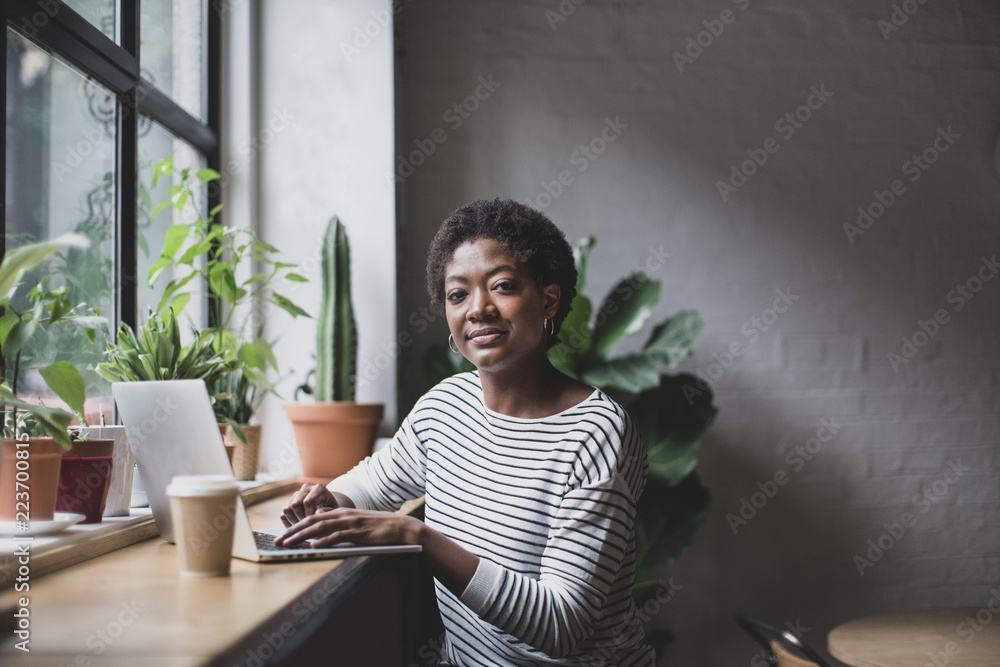 © ReeldealHD images - Portrait of a freelance african american businesswoman working in a cafe