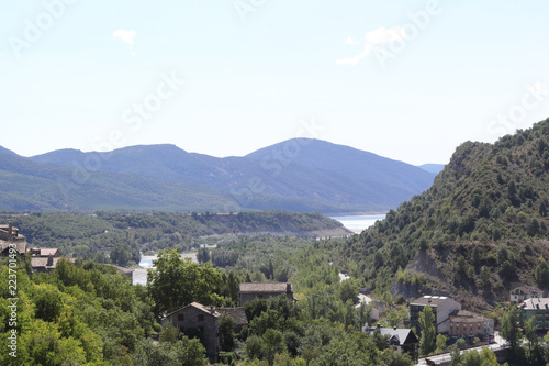 A green landscape of the Mediano artificial lake in the Spanish Aragonese Pyrenees as seen from the traditional small town Ainsa