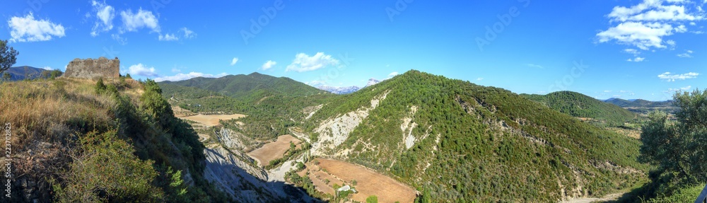 A landscape of cultivated fields, dense forest and mountains as seen from the castle of the rural medieval town of Boltaña, in the Spanish Aragonese Pyrenees
