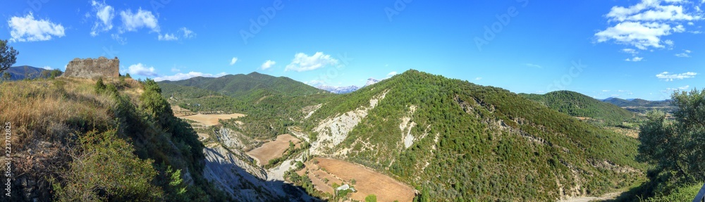 A landscape of cultivated fields, dense forest and mountains as seen from the castle of the rural medieval town of Boltaña, in the Spanish Aragonese Pyrenees A landscape of cultivated fields, dense forest and mountains as seen from the castle of the rural medieval town of Boltaña, in the Spanish Aragonese Pyrenees