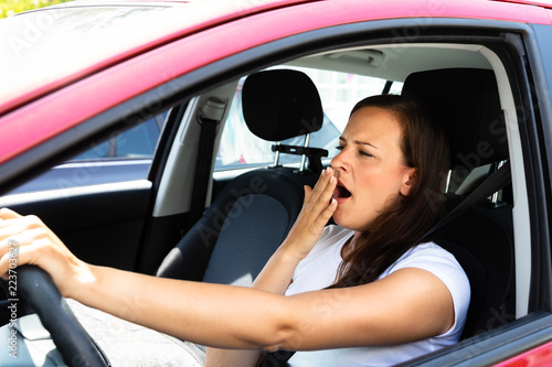 Woman Yawning Inside Car © Andrey Popov