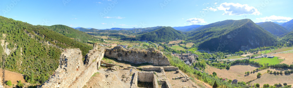 A landscape of cultivated fields, dense forest and mountains as seen from the ruins of the abandoned castle in the rural medieval town of Boltaña, in the Spanish Aragonese Pyrenees A landscape of cultivated fields, dense forest and mountains as seen from the ruins of the abandoned castle in the rural medieval town of Boltaña, in the Spanish Aragonese Pyrenees