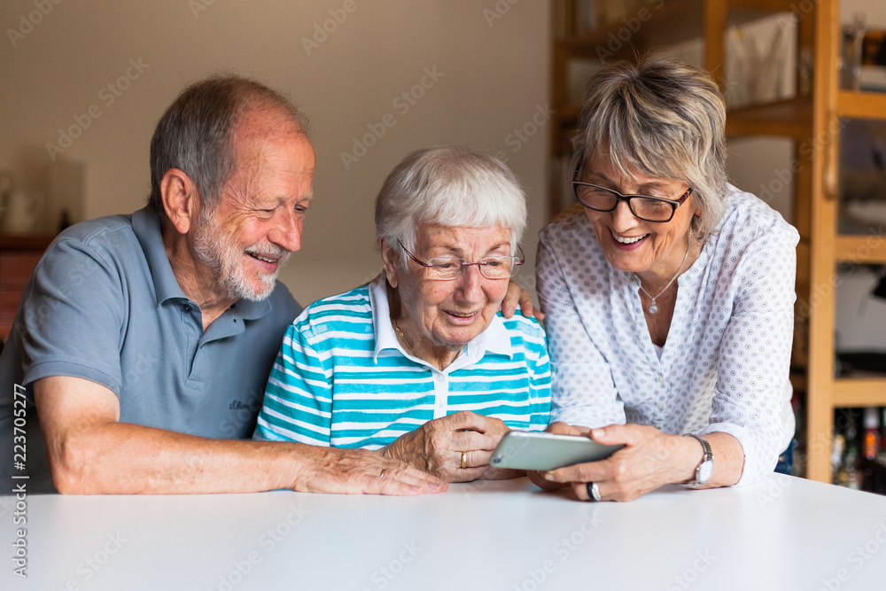 Three elderly persons using smart phone Three elderly persons using smart phone