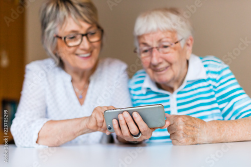 Senior lady using smart phone with her mother