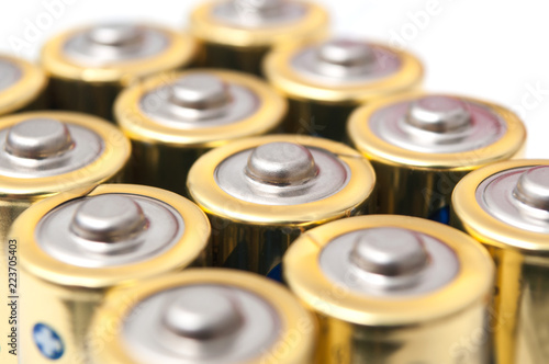 closeup of golden and silver aa alkaline batteries group on white background