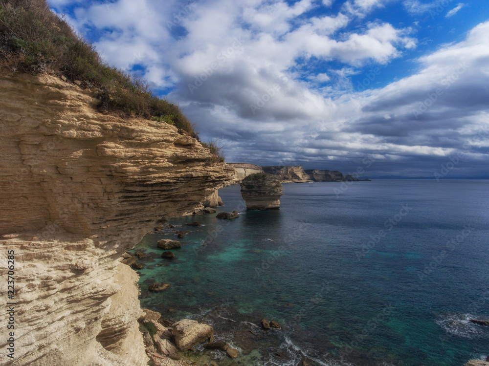 A layered piece of rock protruding above the sea A layered piece of rock protruding above the sea