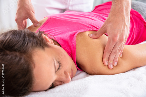 Therapist Giving Shoulder Massage To Female Patient