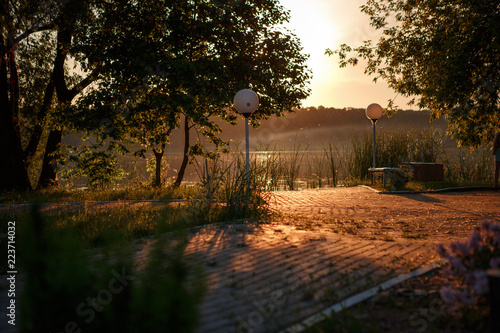 The embankment of the Park at sunset in the orange rays of the sun