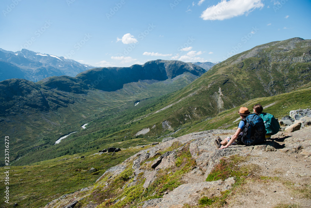 couple of hikers sitting on Besseggen ridge in Jotunheimen National Park, Norway