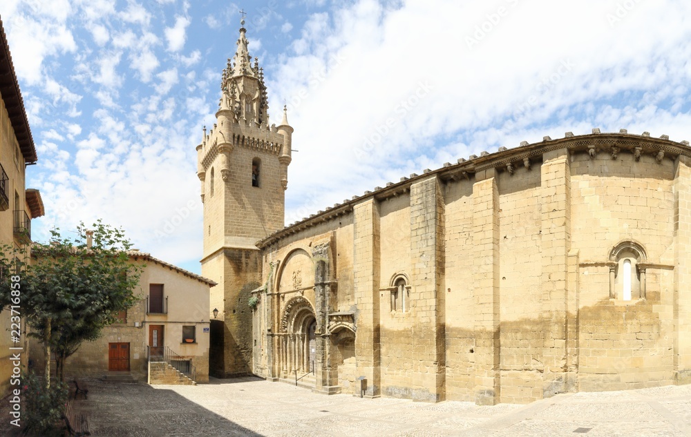 The Holy Mary square and church (Iglesia de Santa Maria) with its bell tower, together with typical stone made Spanish houses in Uncastillo, a small rural town in the Aragon region, in Spain