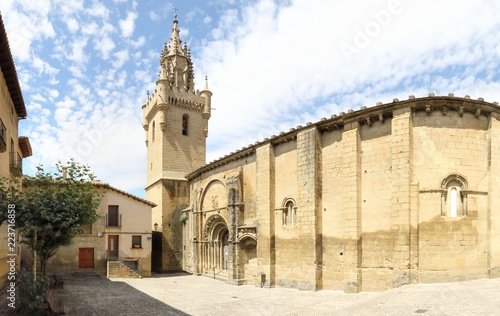 The Holy Mary square and church (Iglesia de Santa Maria) with its bell tower, together with typical stone made Spanish houses in Uncastillo, a small rural town in the Aragon region, in Spain © Isacco