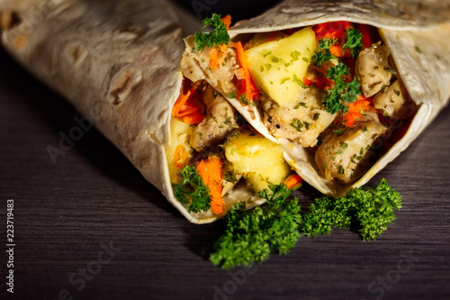 Chicken and pineapple tortilla wrap on dark background