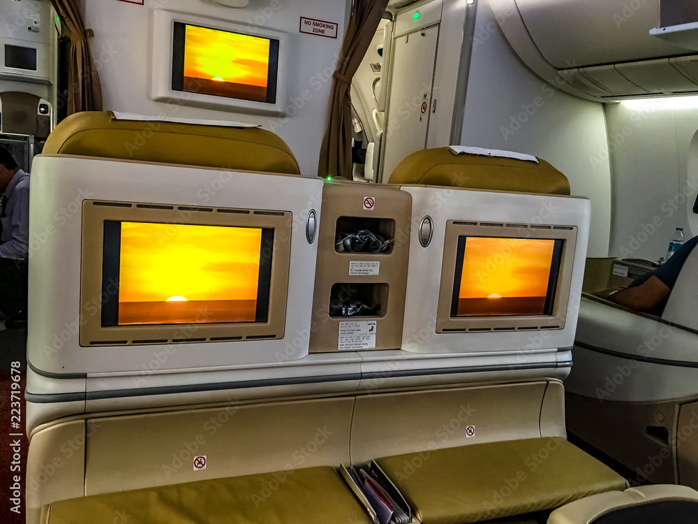 Looking at monitors on the seat backs of a business class seat on an airline.