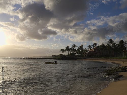 Poipu Beach kurz vor Sonnenuntergang mit Palmen und Mensch mit Boot photo