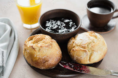 Simple breakfast: coffee americano, fresh buns with jam and juice.