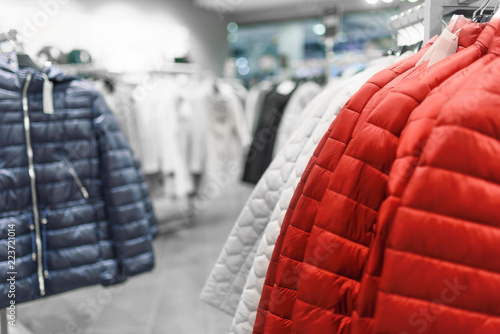 Women's down jackets on hangers in a women's clothing store photo