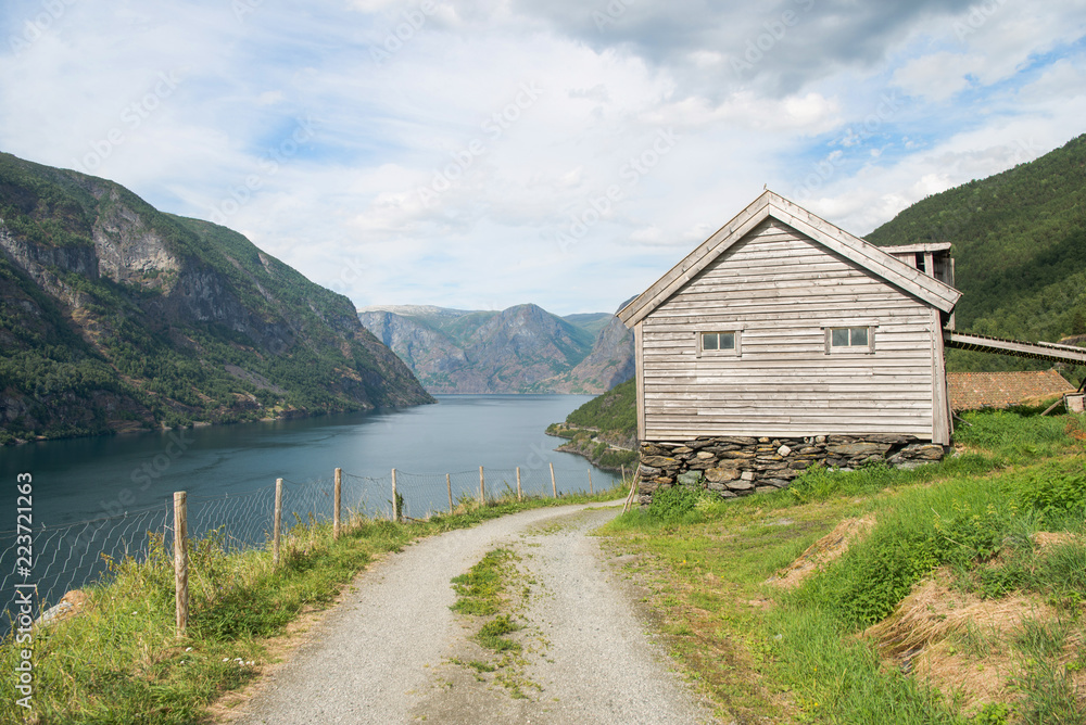rural road and wooden house at majestic Aurlandsfjord, Flam (Aurlandsfjorden), Norway