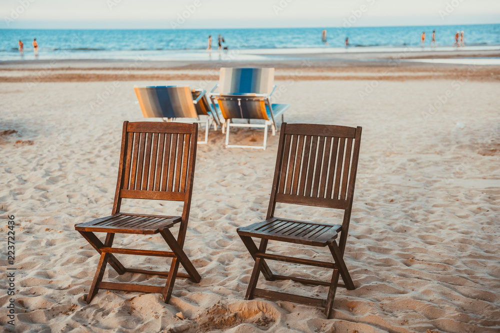 Beach wooden chairs on the sand