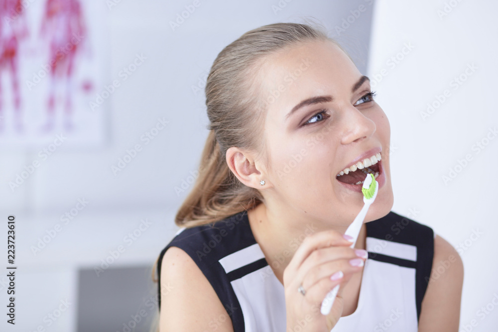 Smiling young woman with healthy teeth brushing her teeth Smiling young woman with healthy teeth brushing her teeth