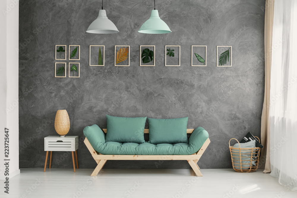 Wooden sofa with mint green cushions by a gray wall with a botanic gallery  in a scandinavian living room interior Stock Photo | Adobe Stock