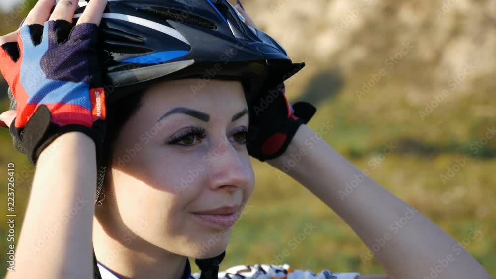 A young woman cyclist adjusts her helmet slow motion A young woman cyclist adjusts her helmet slow motion