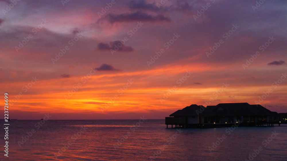 Amazing sunset with seascape and water villas in Maldives.