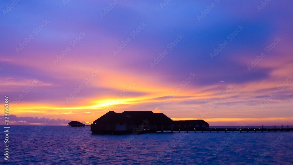Amazing sunset with seascape and water villas in Maldives.