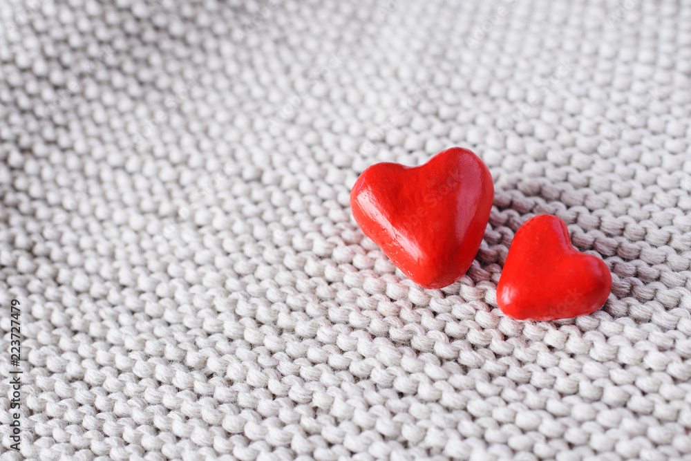 Fototapeta premium two red hearts close-up on knitted background.