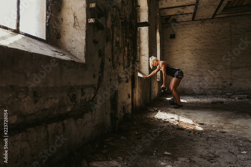 Female athlete workout back by doing kettlebell rows © sasamihajlovic