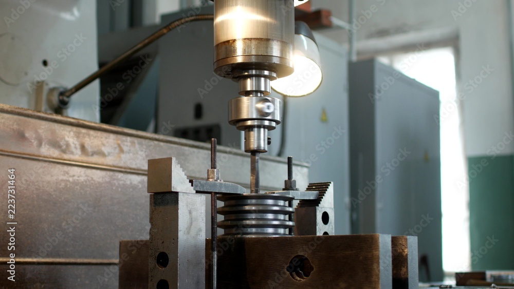 Drilling a hole with a drilling machine in a metal workpiece pulley, close-up, industry, manufacturing pulley Drilling a hole with a drilling machine in a metal workpiece pulley, close-up, industry, manufacturing pulley