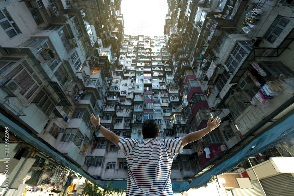 A man is traveling in Hong Kong at famous landmark density residential building.