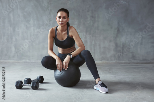 Fototapeta Naklejka Na Ścianę i Meble -  Sports Woman In Fashion Sportswear Sitting On Fitness Ball