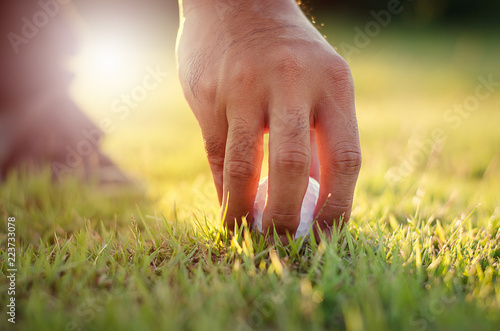 The hands of golfers are holding a golf ball on Putting Green