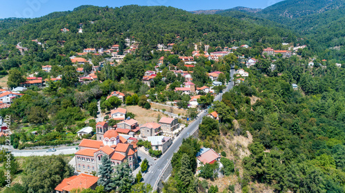 Aerial view of Pano Platres village,winter resort, on Troodos mountains, Limassol, Cyprus. Bird's eye view of pine tree forest, red roof tiled houses, hotels, panagias faneromenis church from above. photo