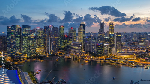 A view of Singapore business district skyscrapers at evening with water reflections day to night timelapse