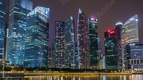 A view of Singapore business district skyscrapers in the night time with water reflections timelapse hyperlapse