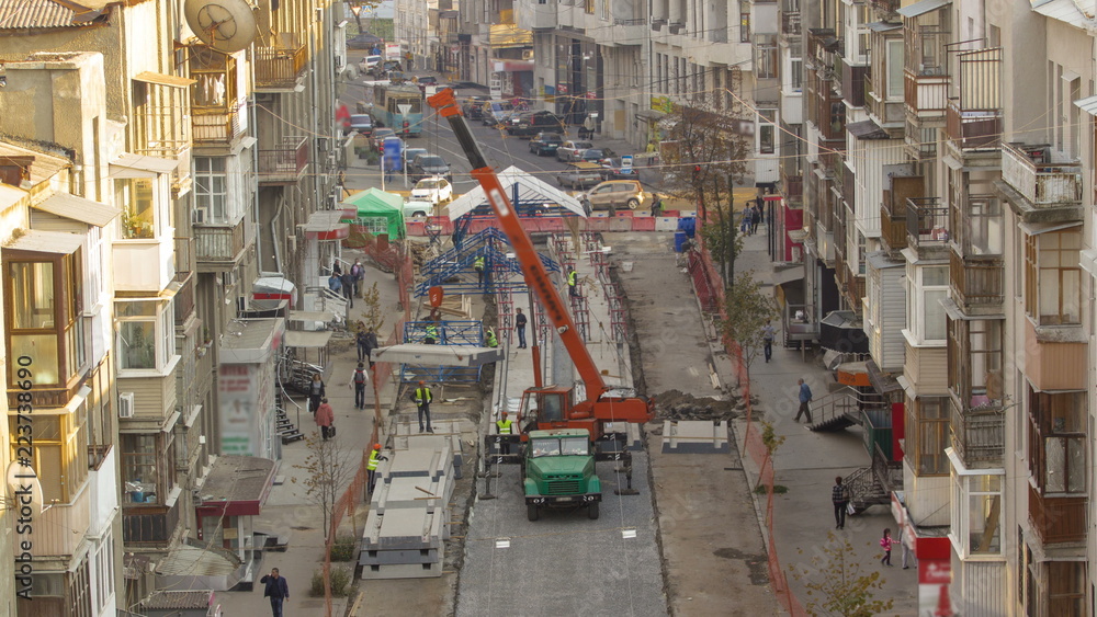 Naklejka premium Unloading concrete plates from truck by crane at road construction site timelapse.