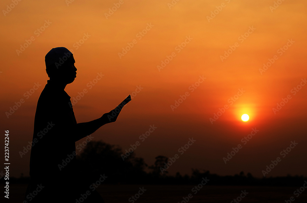 Fototapeta premium Silhouette Muslim men are chanting the light of sunset