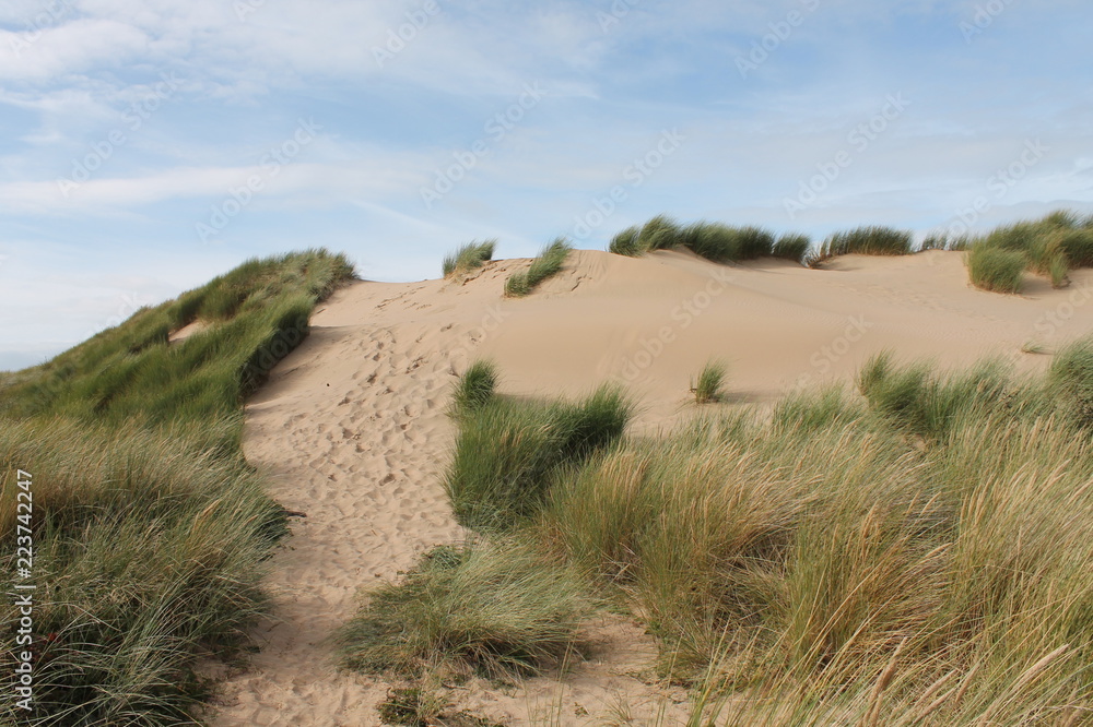sand dune at the beach being blown by the wind at formby beach